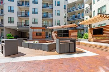A modern outdoor seating area with wooden and concrete furniture at Regatta Sloans Lake Apartments, Denver